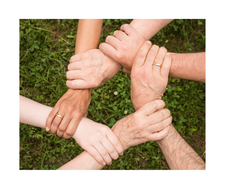 6 Hände, die einander fassen als Zeichen für Zusammenhalt.